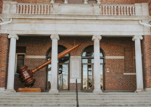 a-large-wooden-object-sitting-in-front-of-a-building-db7aznobnps